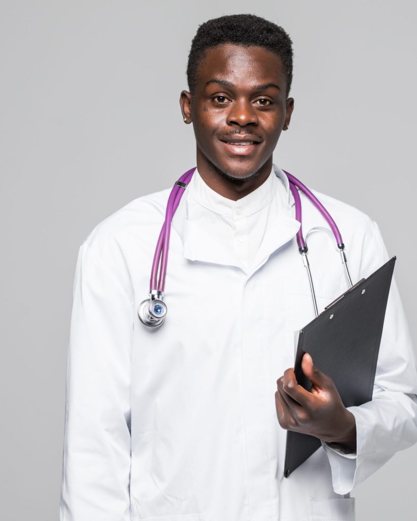 Friendly Afro-American doctor holding a clipboard and smiling at the camera